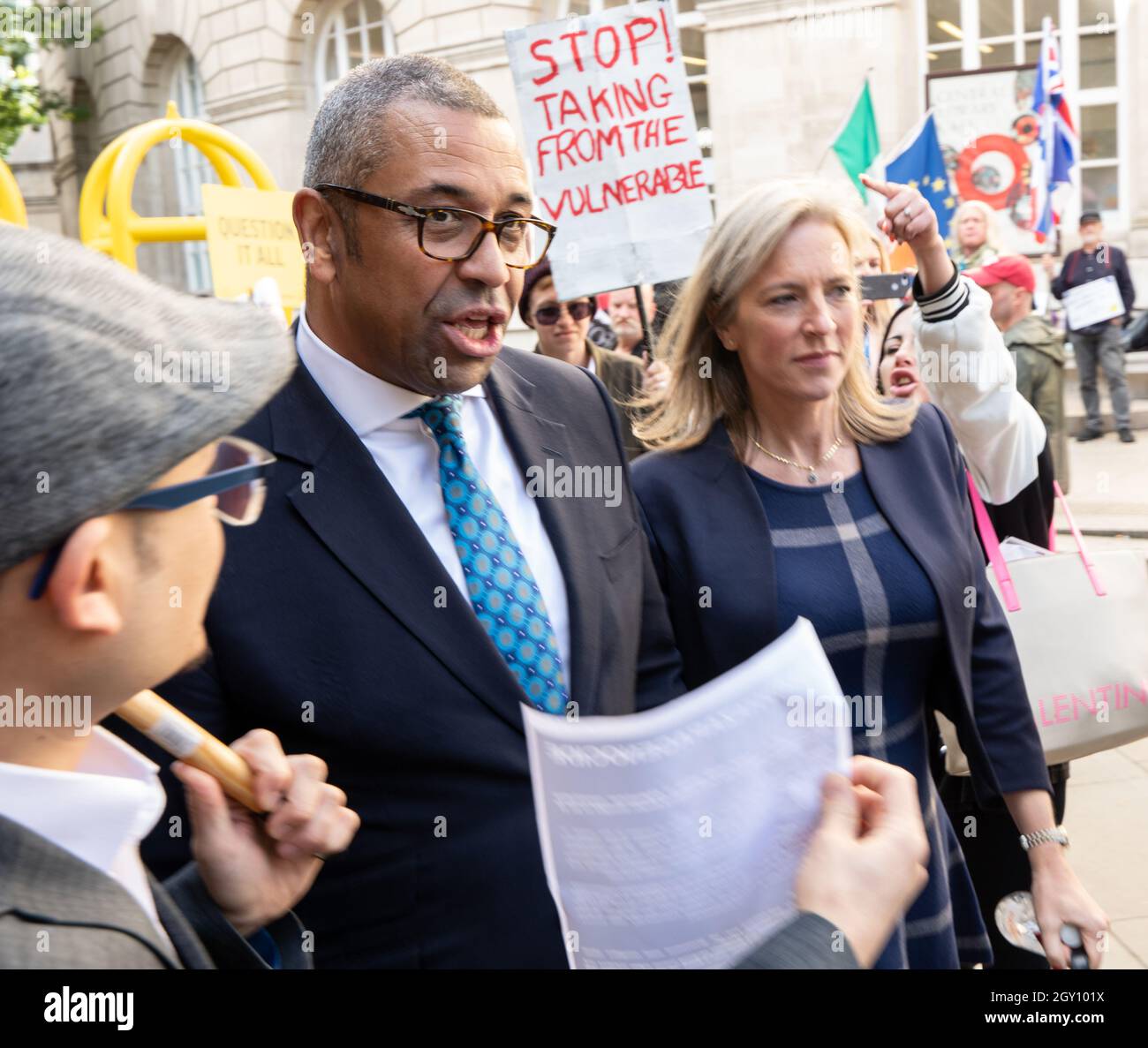 Manchester, uk, 6th October 2021, James Cleverly Minister of State for Middle East and North Africa and his wife Susannah brave anti government protesters as they leave the last day of the Conservative conference on foot. St Peters Sq . James Cleverly is the Conservative MP for Braintree, and holds the Government post of Minister of State (Foreign, Commonwealth and Development Office). Manchester UK  Picture credit garyroberts/Alamy Live News Stock Photo