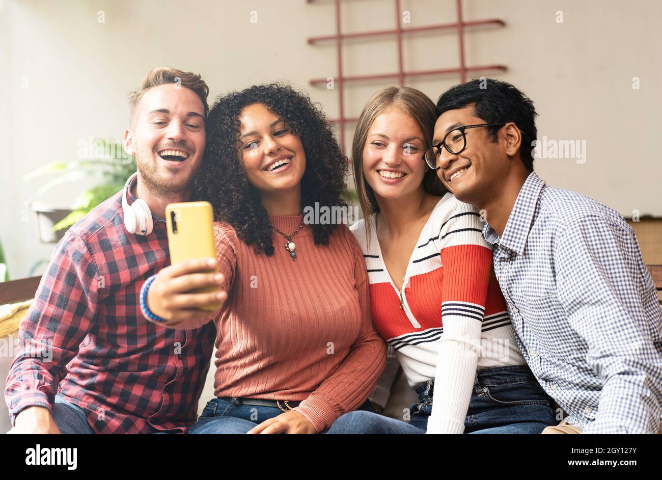 Young friends group making selfie with smartphone - Community concept with multicultural and multiethnic friends having fun video calling with friends Stock Photo