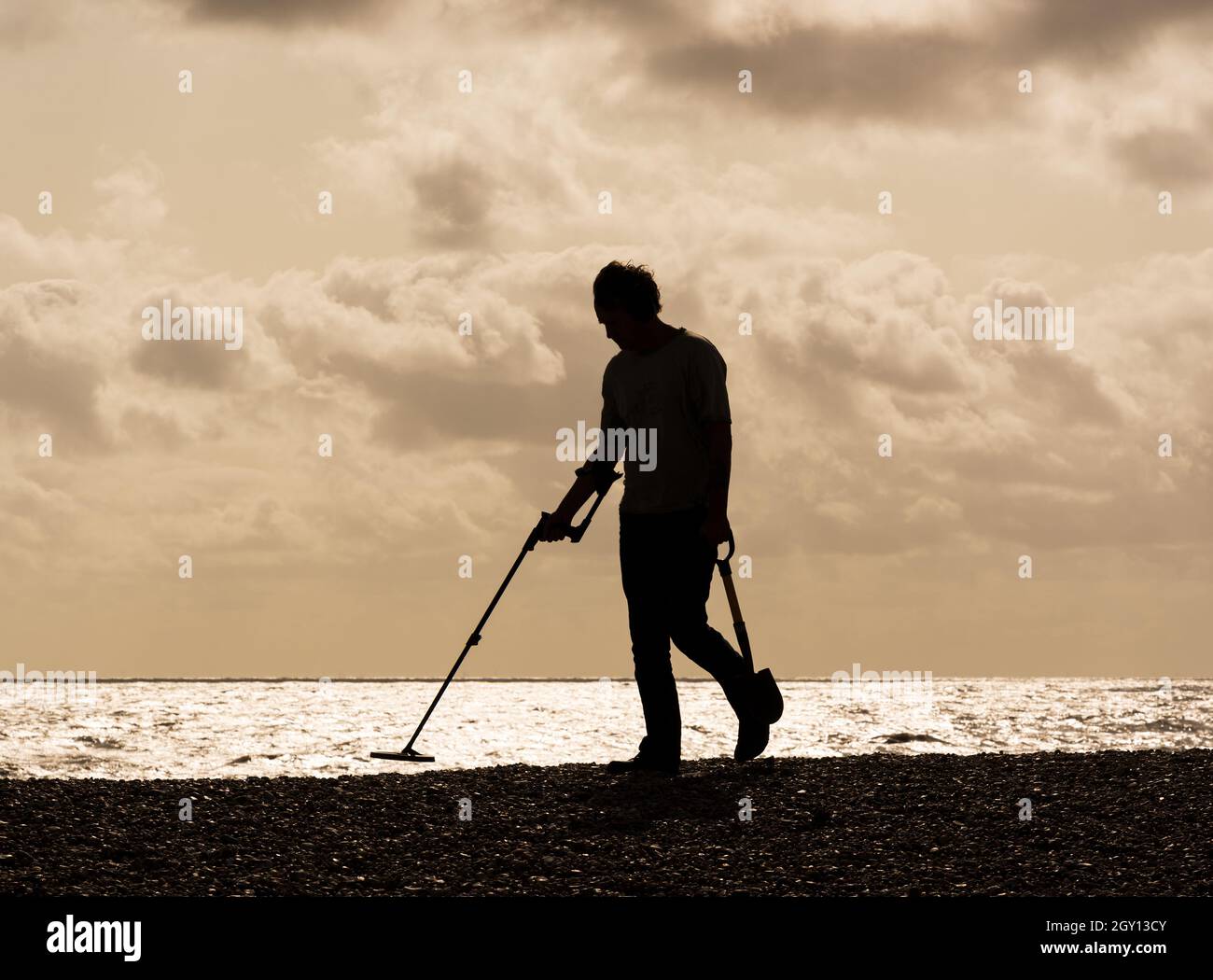 Treasure hunter with a metal detector on the beach. Aldeburgh, Suffolk. UK Stock Photo