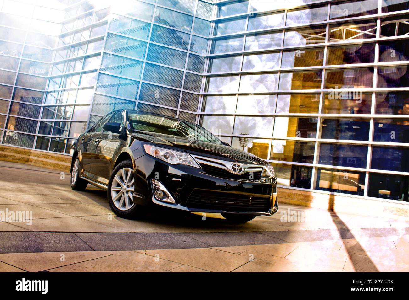 Toyota Camry in an urban setting with a glass-paneled building in the background Stock Photo