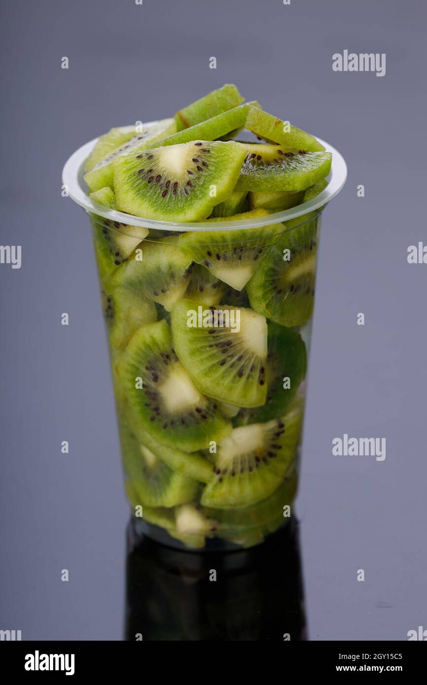 Kiwi fruit slices or cut piece arranged in a glass with black color background. Stock Photo