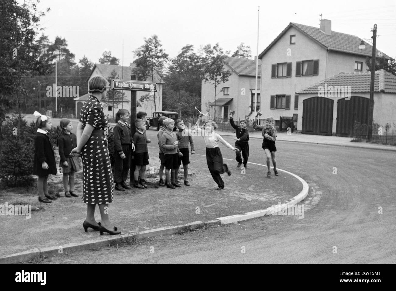 Eine Schulklasse testet draußen unter Aufsicht der Lehrerin die selbstgebastelten Flugobjekte, Zeppelin Siedlung bei Frankfurt am Main, Deutschland 1930er. A class and their teacher are testing the self made aircrafts outside, zeppelin village near Frankfurt am Main, Germany 1930s. Stock Photo