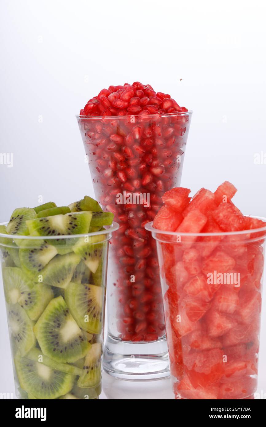 Watermelon , pomegranate and Kiwi Slices arranged  in two transparent glasses with white background, isolated Stock Photo