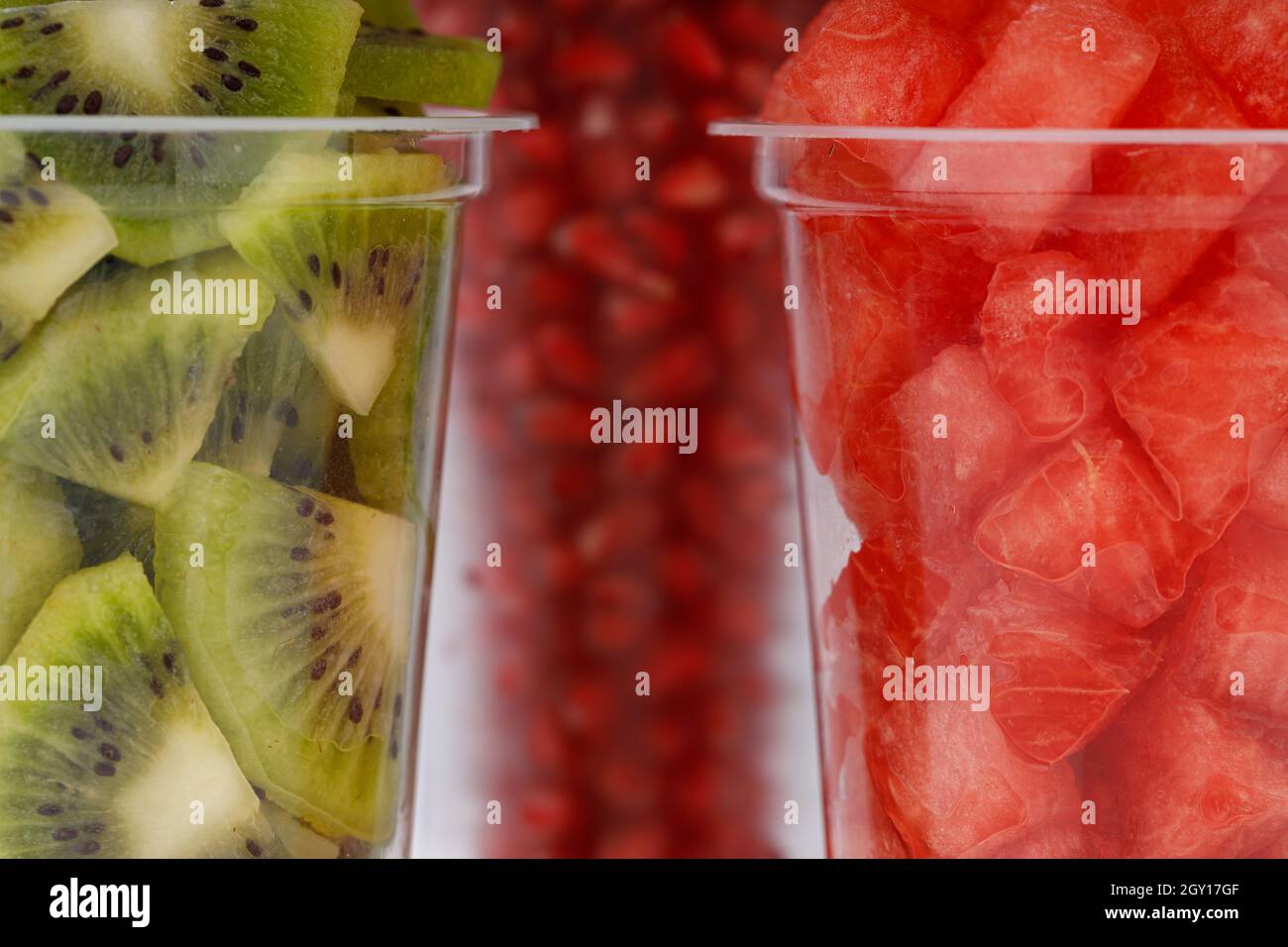 Watermelon , pomegranate and Kiwi Slices arranged  in two transparent glasses with white background, isolated Stock Photo