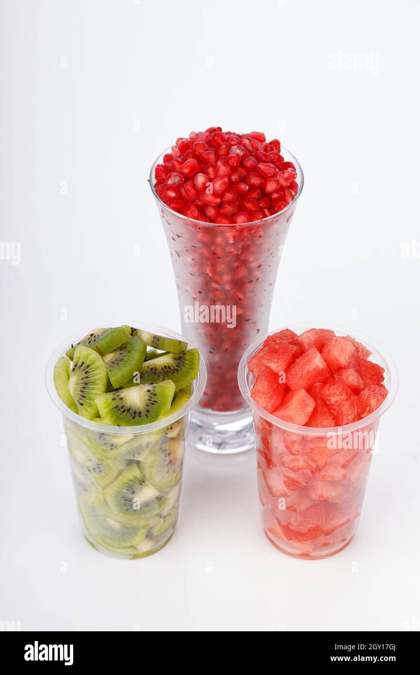 Watermelon , pomegranate and Kiwi Slices arranged  in two transparent glasses with white background, isolated Stock Photo