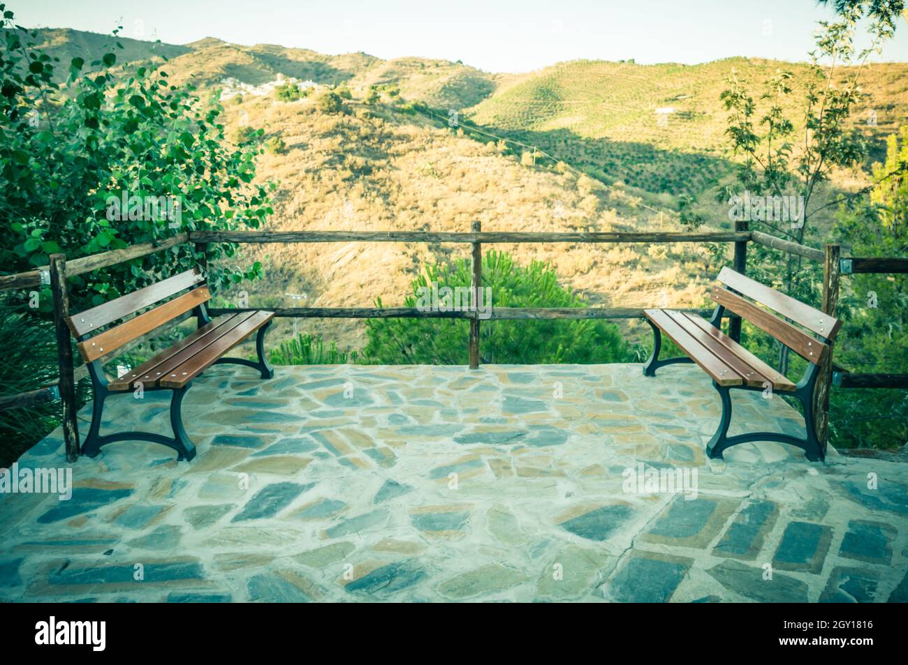 Benches facing each other on the viewpoint in Macharaviayain, Malaga, Spain Stock Photo