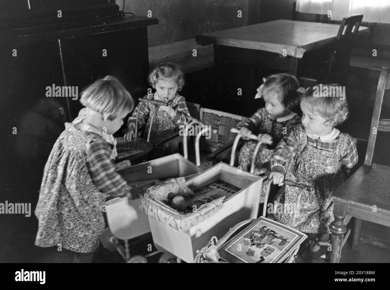 Die Knipser Vierlinge als Kleinkinder mit ihren Puppenwagen, Deutschland 1930er Jahre. Knipser's quadruplet girls with their doll's prams, Germany 1930s. Stock Photo