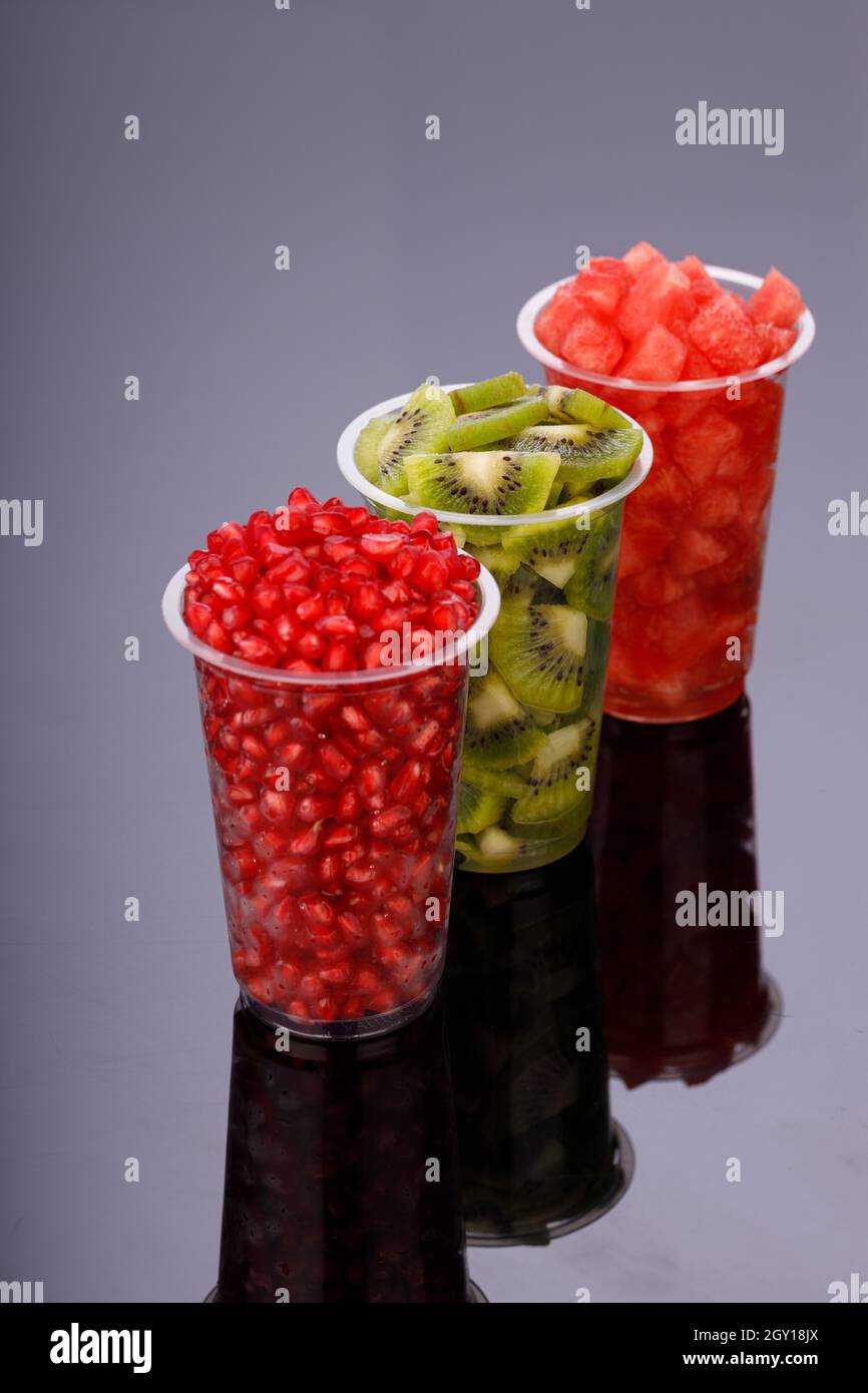 Watermelon , pomegranate and Kiwi  Slices arranged  in two transparent glasses with white background, isolated Stock Photo