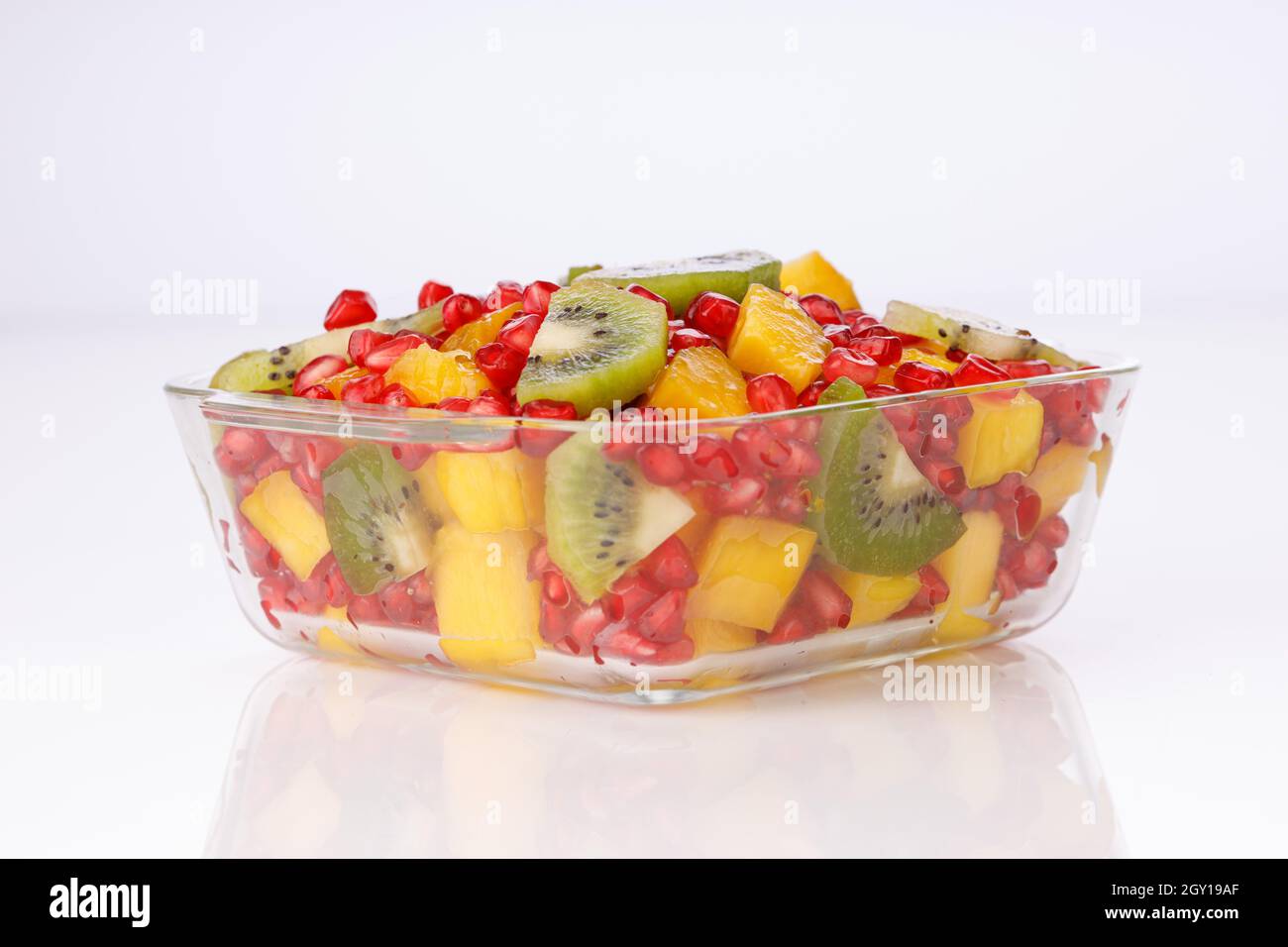 Mixed cut fruits arranged in a transparent glass bowl  with white background, isolated. Stock Photo