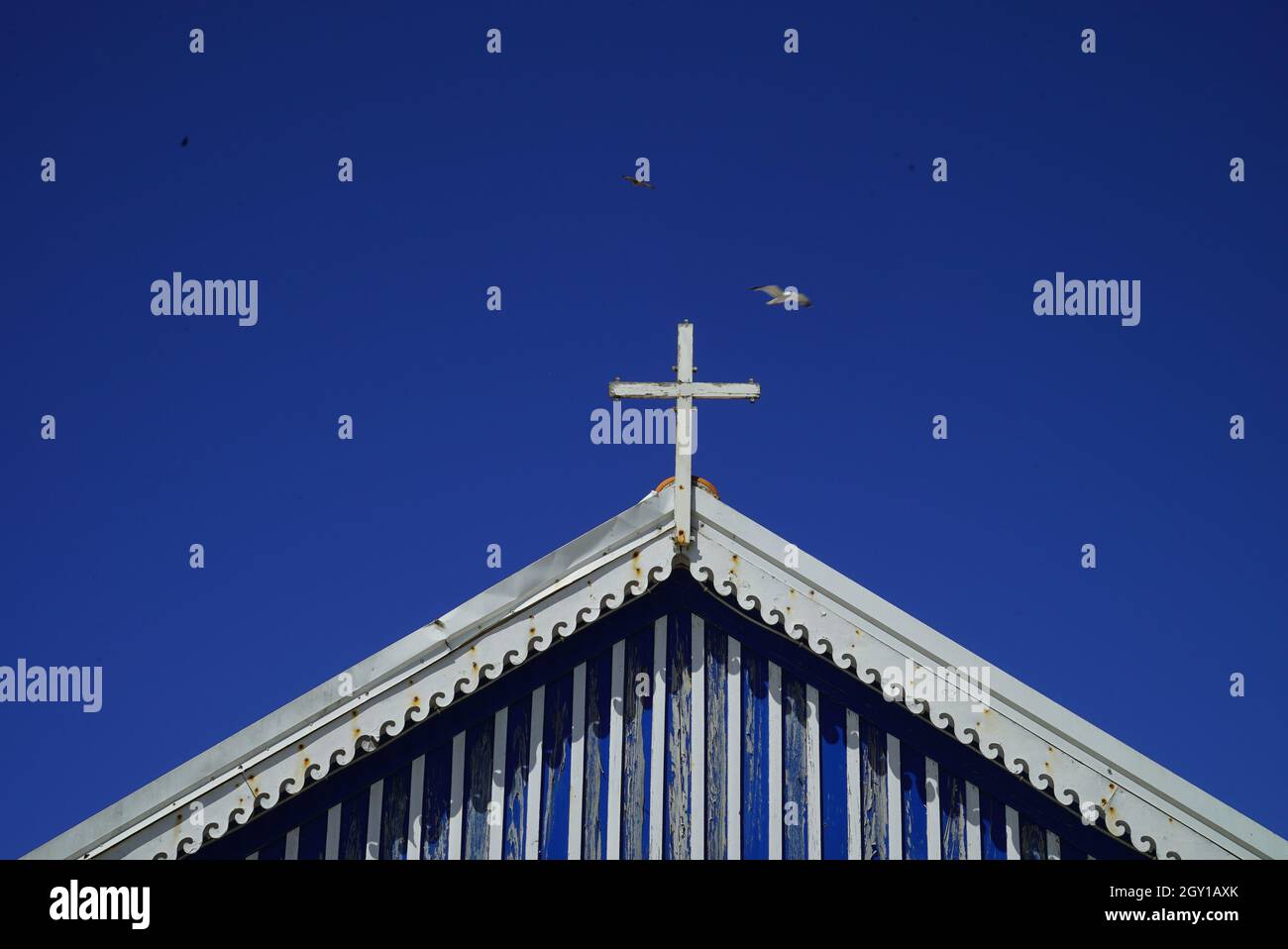 Low angle shot of a church with a white cross on top of it under the ...