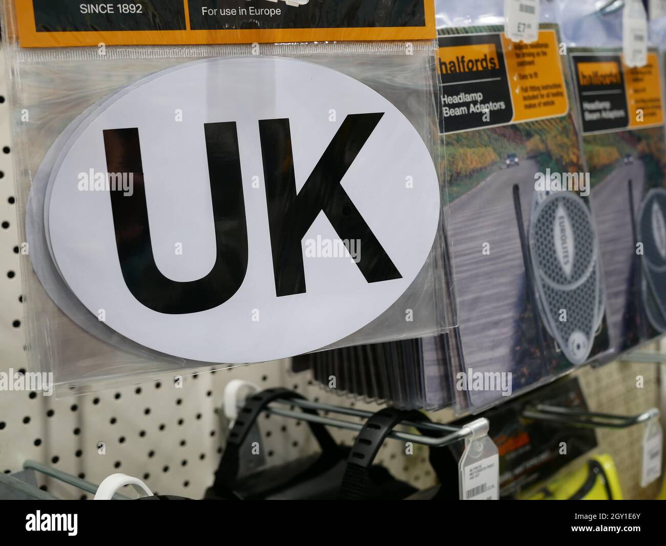 UK identifier car sticker for sale in a Halfords store. When travelling overseas motorists must now display the UK logo on the rear of their vehicle. Stock Photo