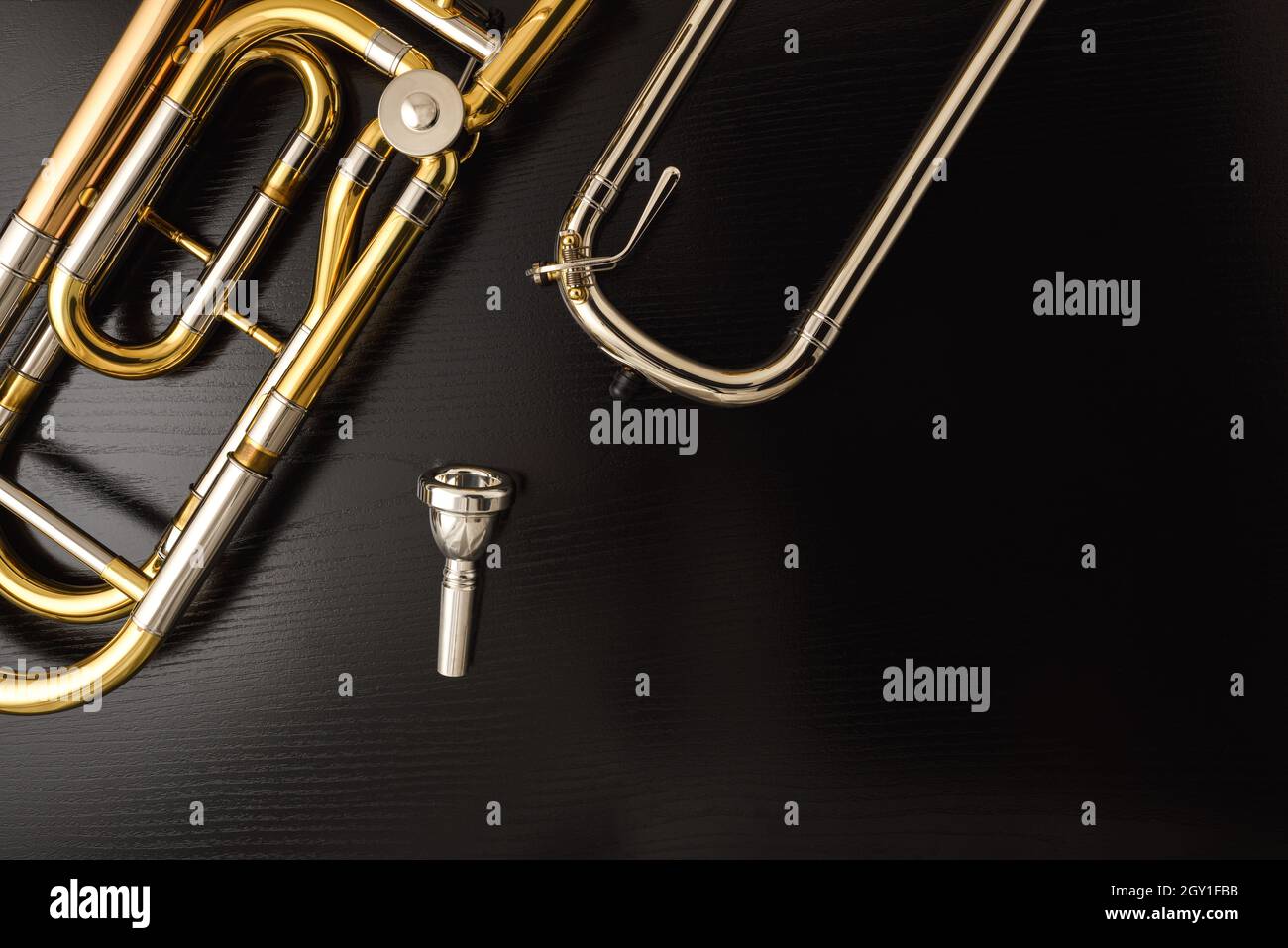 Detail of parts of a trombone with transposer on black wooden table