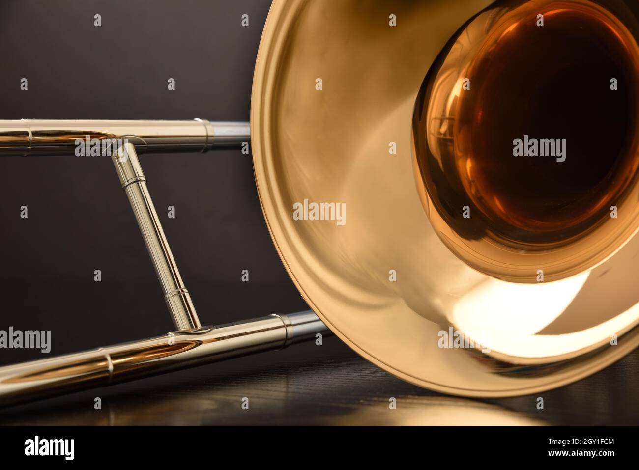 Trombone bell and slide detail on table and black background. Front view. Horizontal composition. Stock Photo