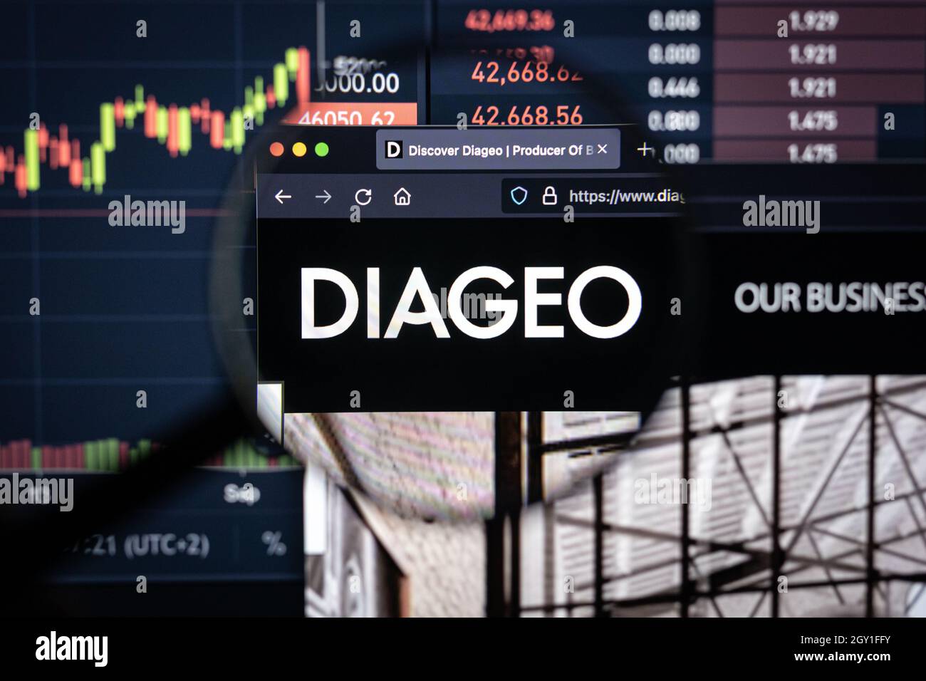 Diageo company logo on a website with blurry stock market developments in the background, seen on a computer screen through a magnifying glass Stock Photo
