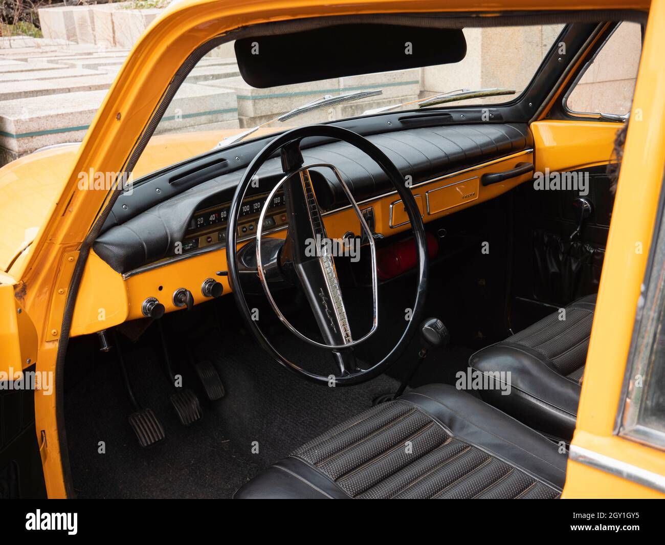 Stekene, Belgium, September 25, 2021, The inside and the steering wheel and dashboard of an orange old-timer Volvo 122s Stock Photo