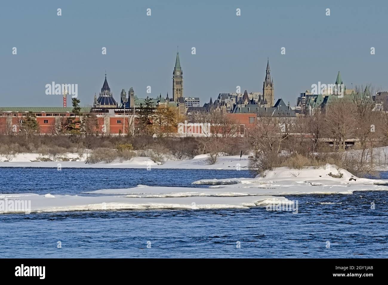Neo gothic government buildings of Parliament hill, Ottawa, view from across the river with ice on a sunny winter day Stock Photo