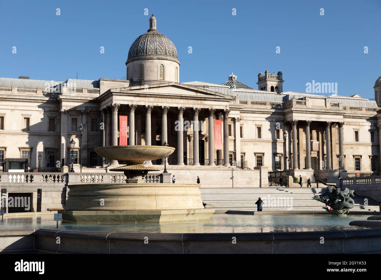 Fountain on Trafalgar Square, in front of the National Gallery, in London, England. William Wilkins designed the Neoclassical building. Stock Photo