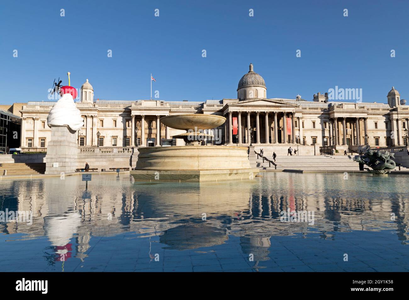 Fountain on Trafalgar Square, in front of the National Gallery, in London, England. William Wilkins designed the Neoclassical building. Stock Photo