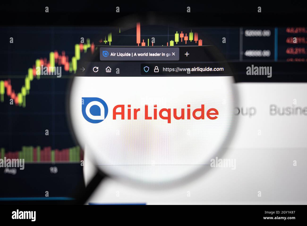 Air Liquide company logo on a website with blurry stock market developments in the background, seen on a computer screen through a magnifying glass Stock Photo
