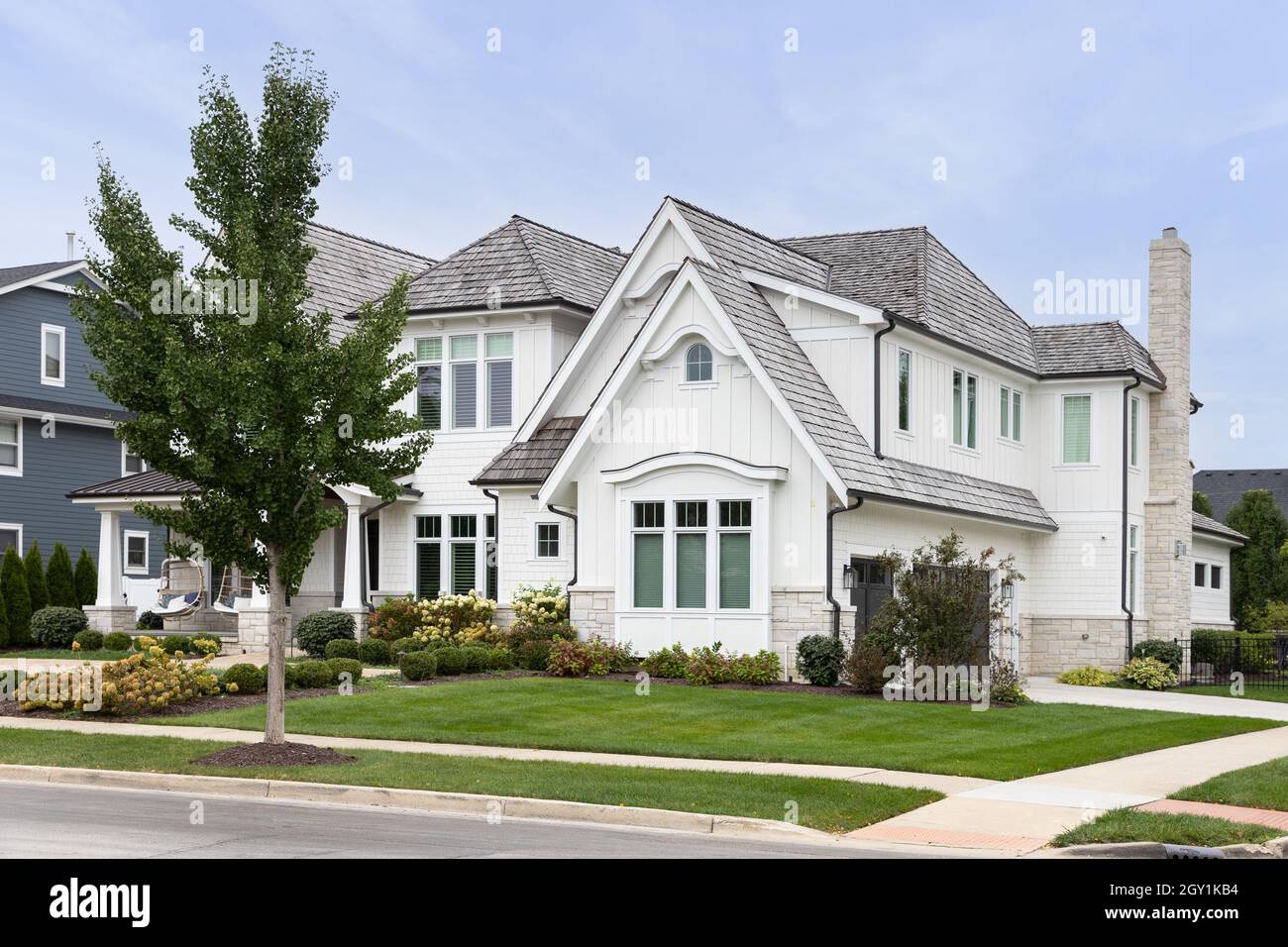A beautiful modern farmhouse with white siding, a covered front porch