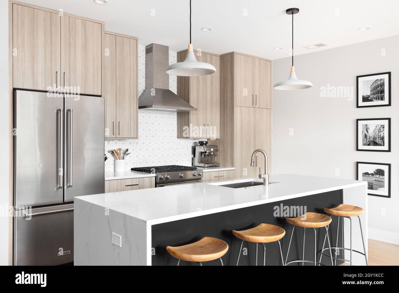 A beautiful, modern kitchen with a dark grey island with a white marble