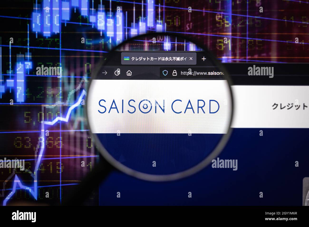 Saison Card company logo on a website with blurry stock market developments in the background, seen on a computer screen through a magnifying glass Stock Photo