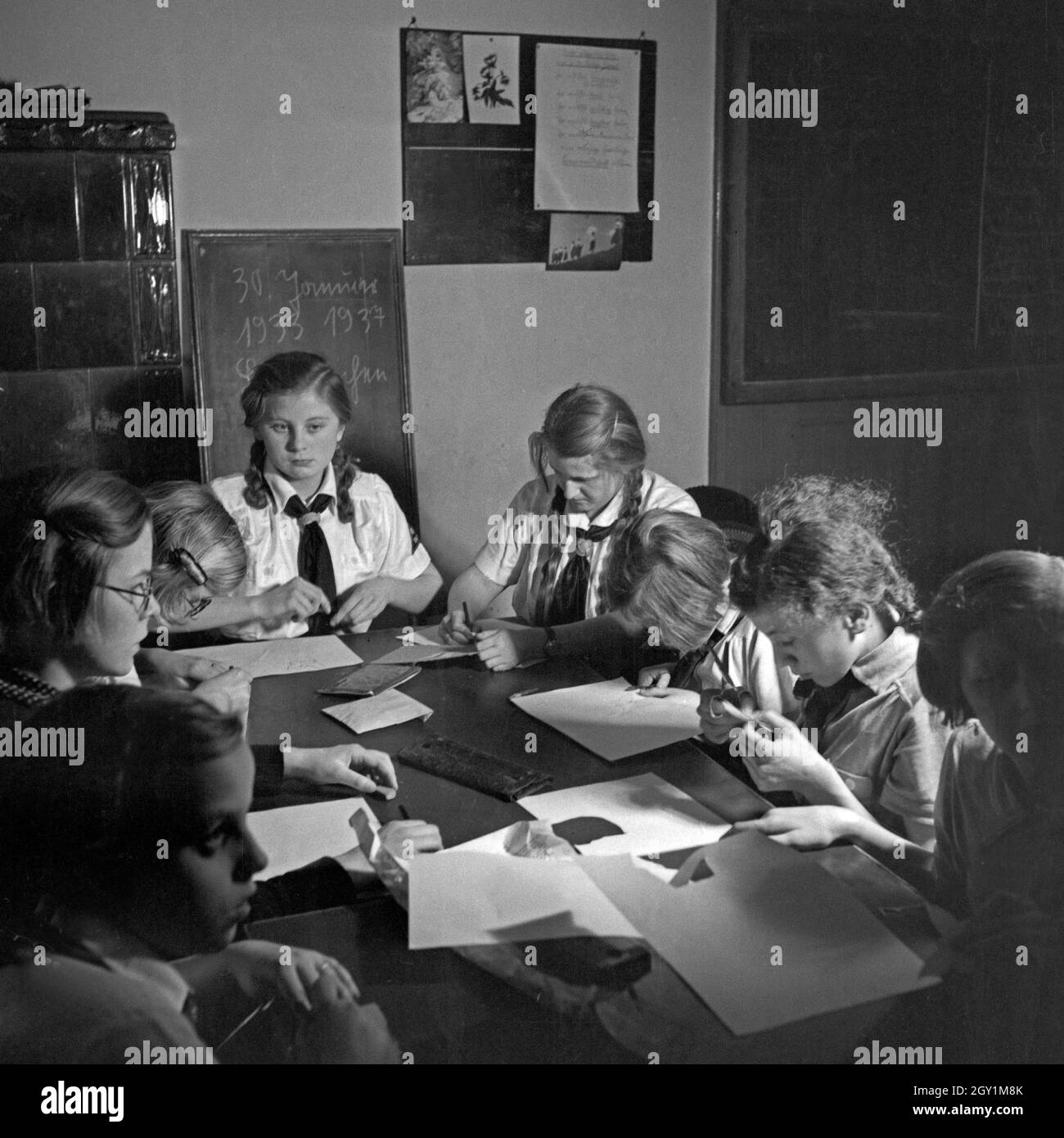 BdM Mädchen beaufsichtigen die Bastelstunde von Kindern einer Taubstummenschule, Deutschland 1930er Jahre. BdM girls supervising the children at a school for the deaf mute, Germany 1930s. Stock Photo