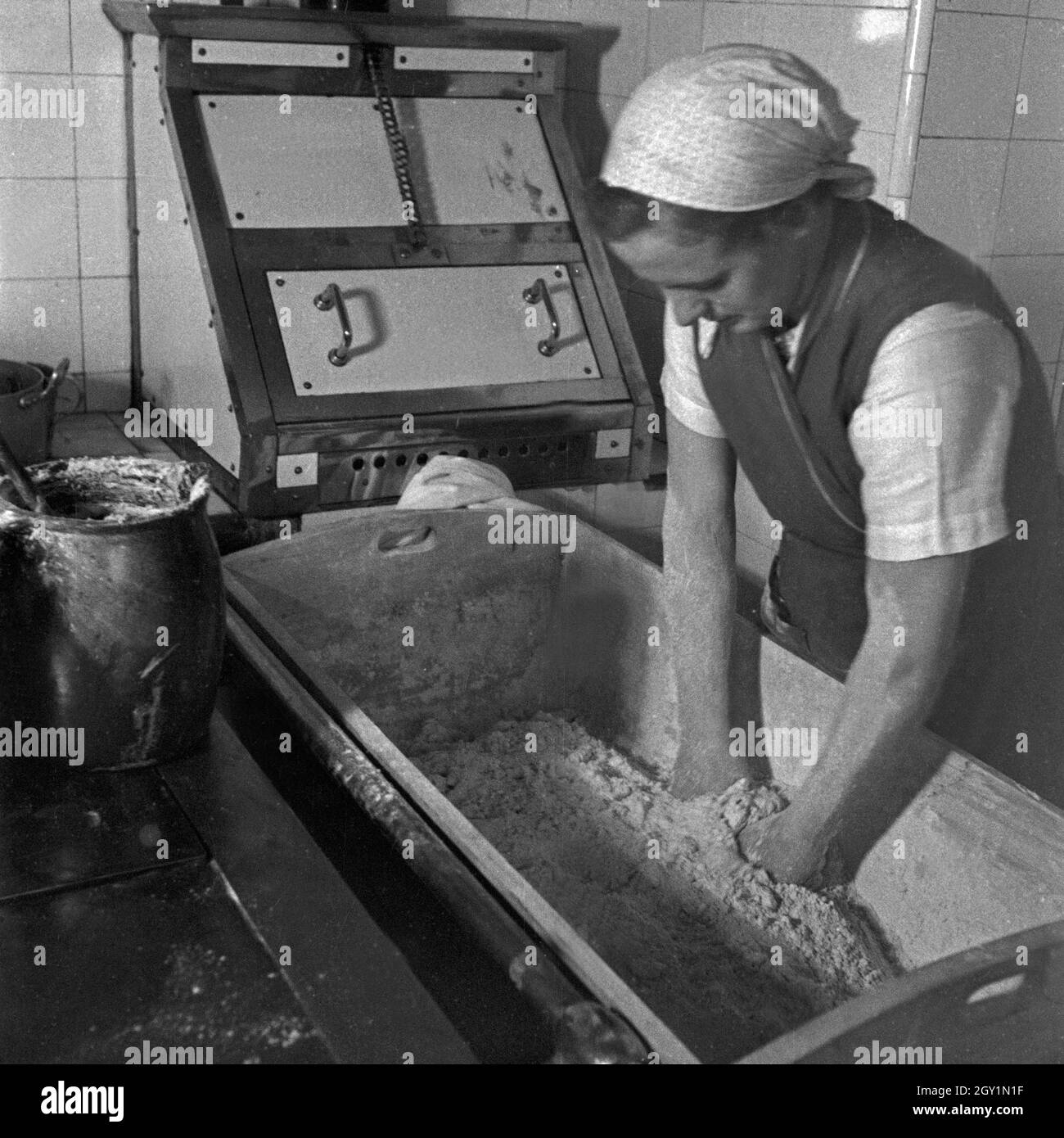 Eine Frau beim Teigkneten beim weiblichen Arbeitsdienst in Molkenberg bei Fürstenwalde, Deutschland 1930er Jahre. A woman mixing some dough at the female workforce group of Molkenberg, Germany 1930s. Stock Photo