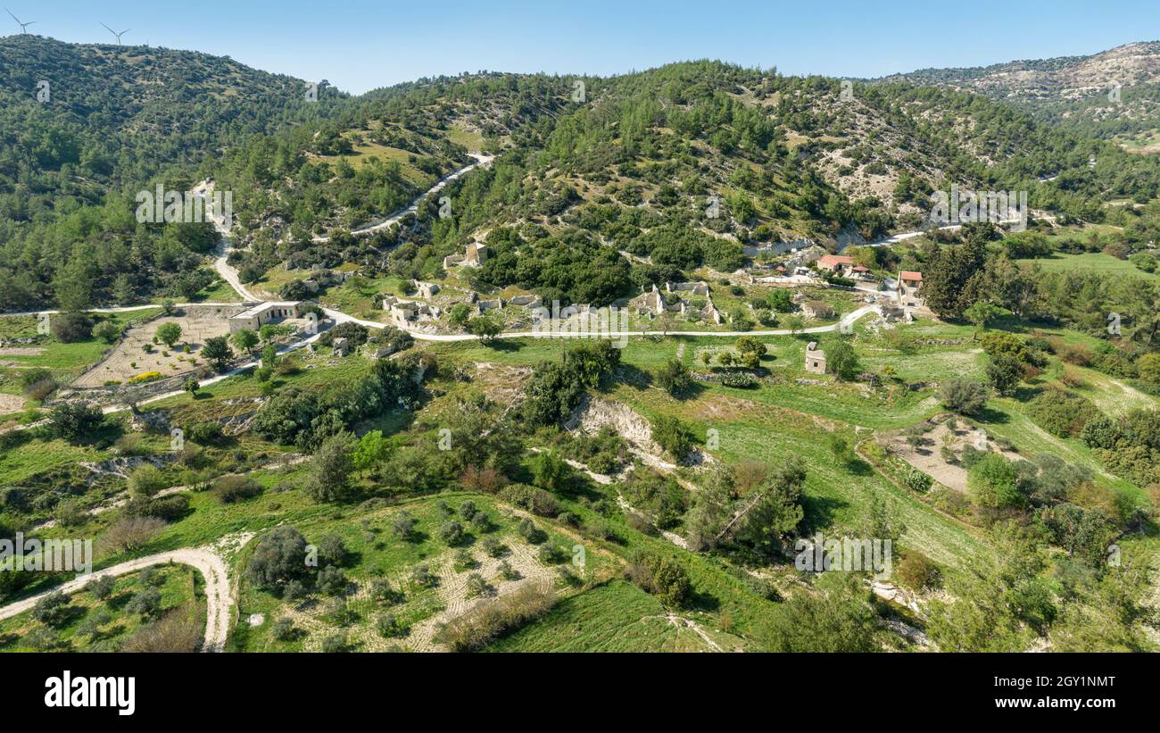 Rural depopulation in Cyprus. Semi-abandoned village of Kato Archimandrita on a hill slope with old ruins and renovated Stock Photo