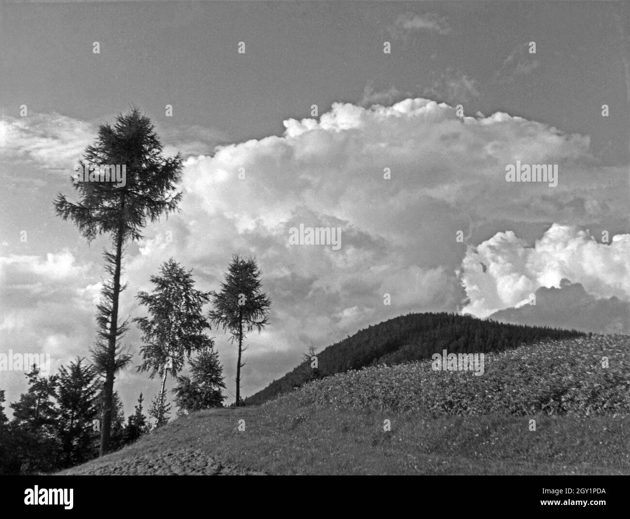 Eine Landschaft mit Wolkenspiel am Himmel, Deutschland 1930er Jahre. A landscape with a flock of clouds in the sky, Germany 1930s. Stock Photo