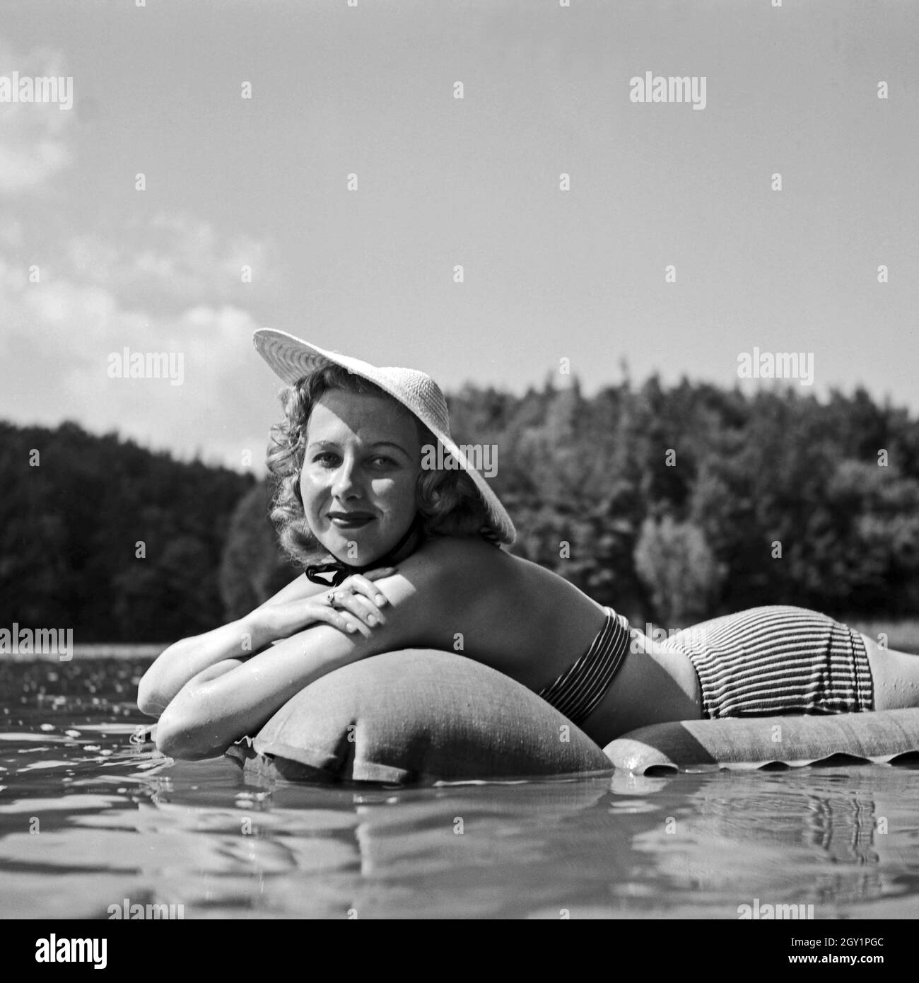 Ein junge Frau liegt im See auf ihrer Luftmatratze, Deutschland 1930er ...