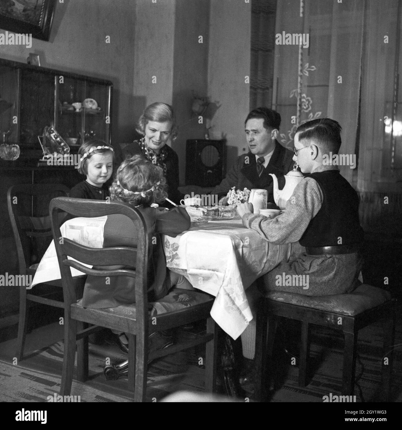 Eine Familie sitzt im Wohnzimmer am Kaffeetisch, Deutschland 1930er Jahre.  A family sitting at the tabele, having coffee, Germany 1930s Stock Photo -  Alamy