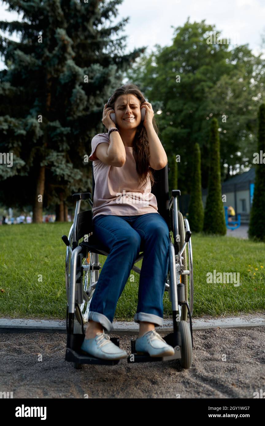 Disabled woman in wheelchair listens to music Stock Photo - Alamy