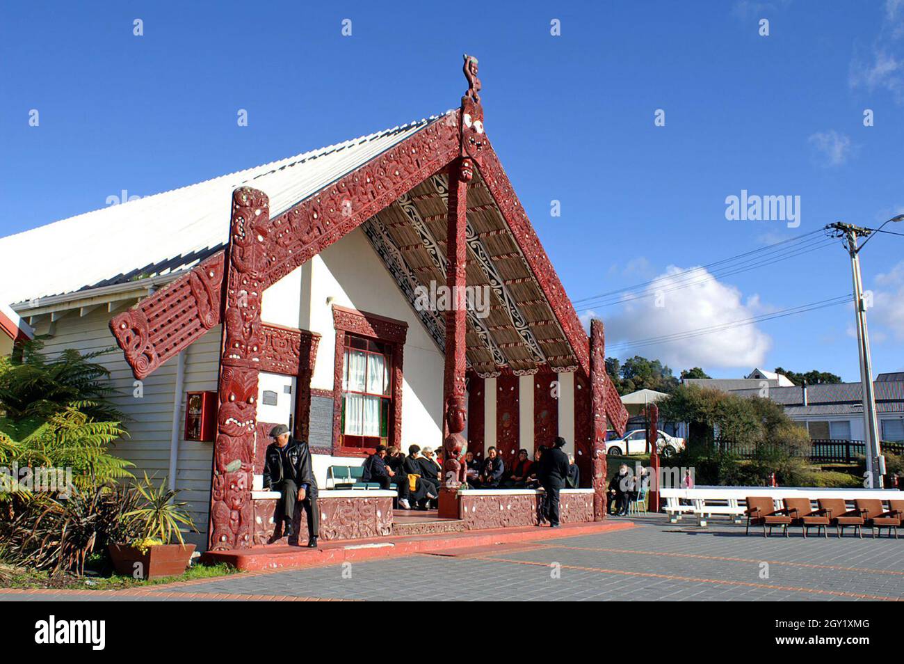 People gather at a meeting house on a marae for a funeral.  The meeting house, also known as a whare or wharenui, is a central meeting place for the Maori community in New Zealand. Stock Photo