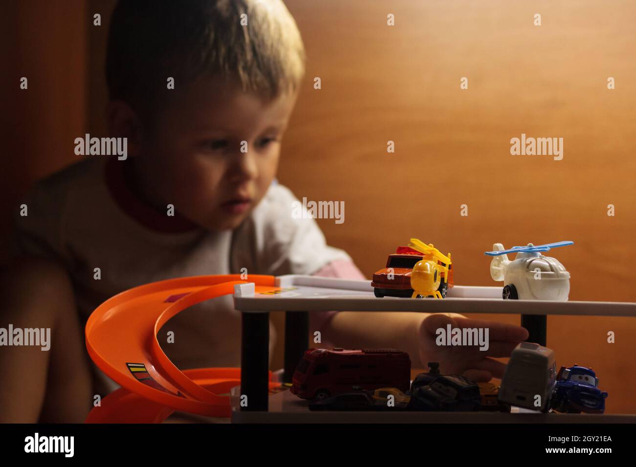 Little boy playing toy cars. Child driving car to parking garage. Kids