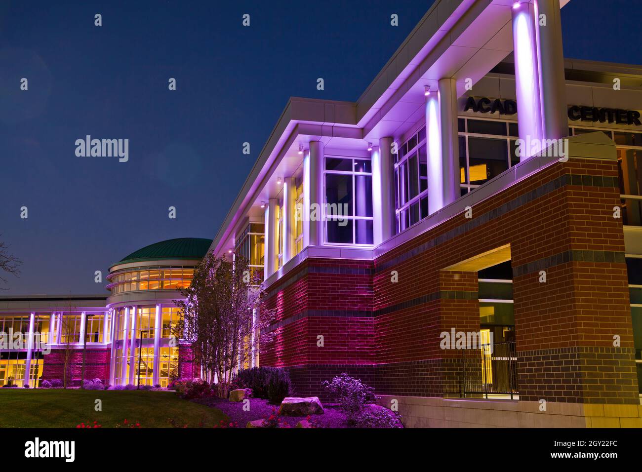 Worms eye view of the modern building with many windows at twilight lit up purple Stock Photo