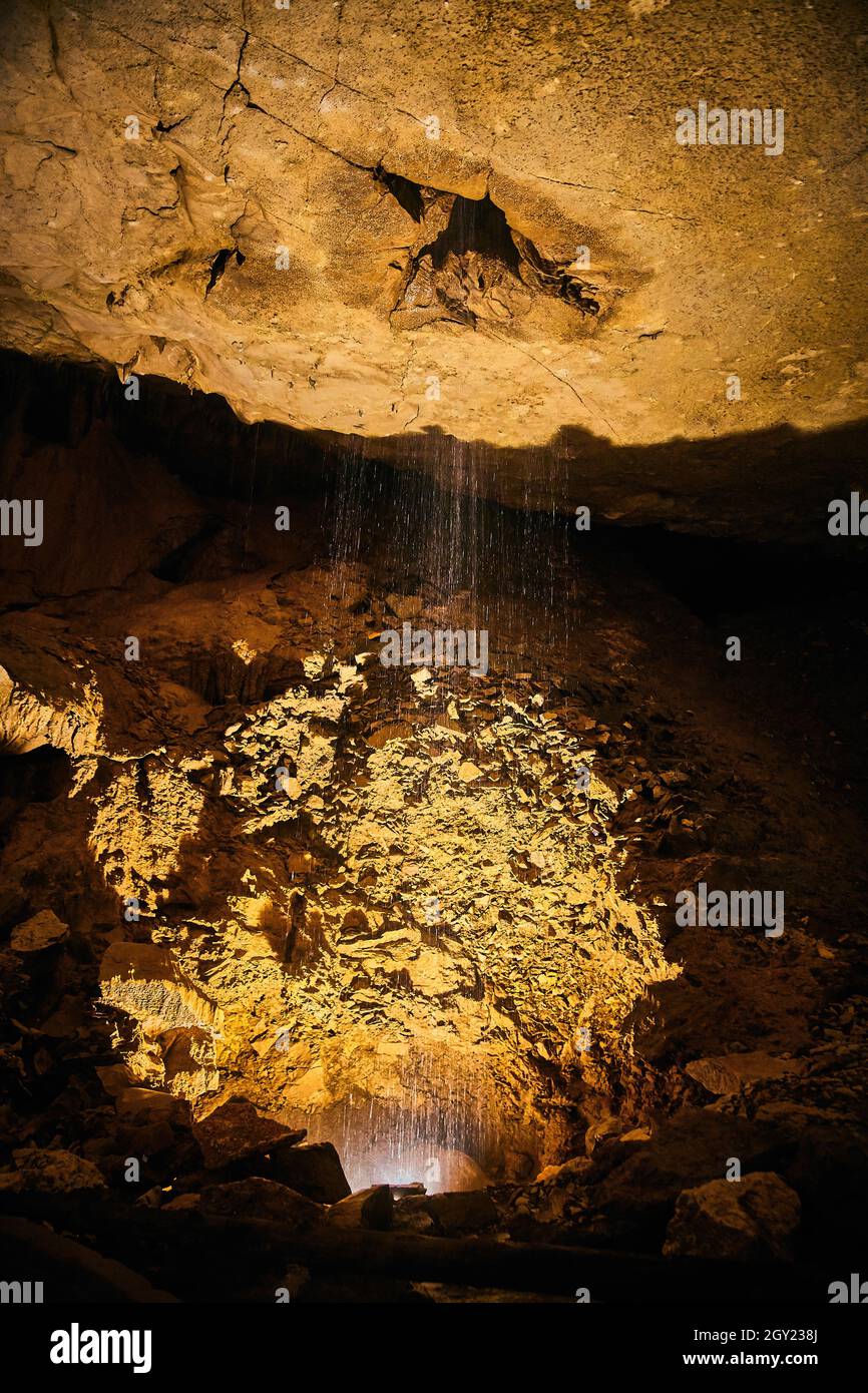 Water dripping into cave formations yellow Stock Photo