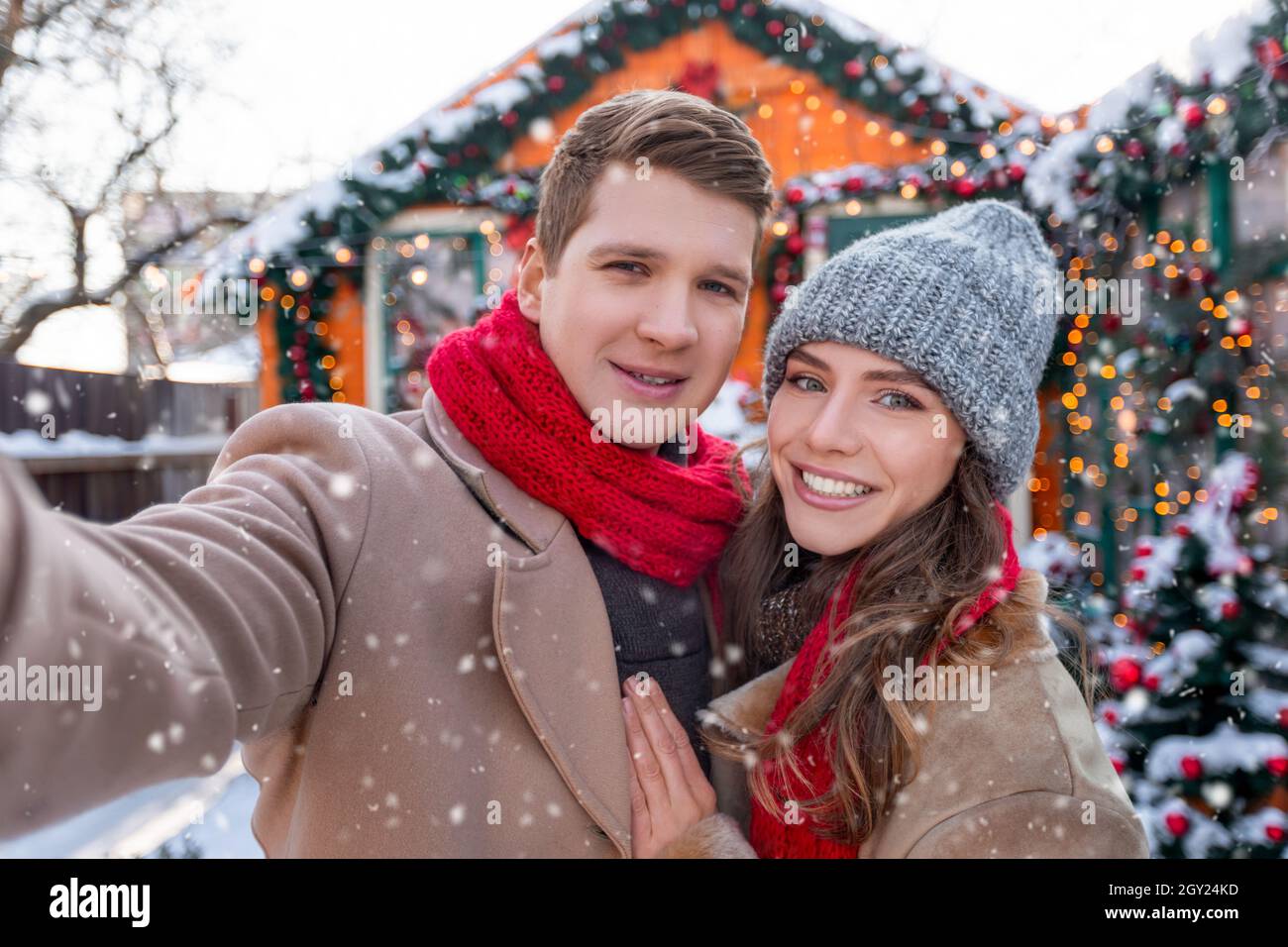 Cheerful lovers taking selfie while spending snowy day outside Stock Photo