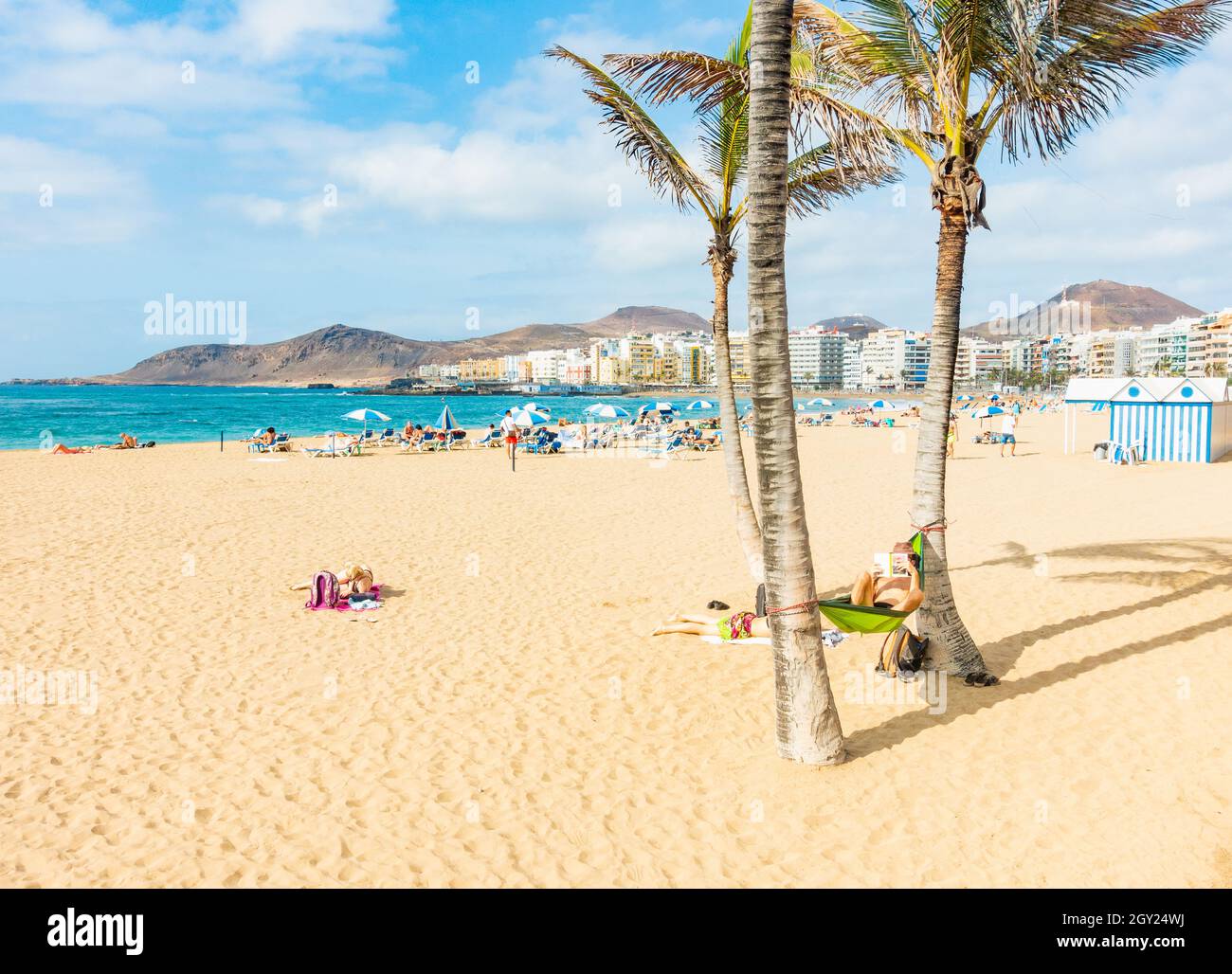 Gran Canaria, Canary Islands, Spain. 6th October, 2021. Tourists, many from  the UK, basking in glorious early evening sunshine on the city beach in Las  Palmas on Gran Canaria as a volcano