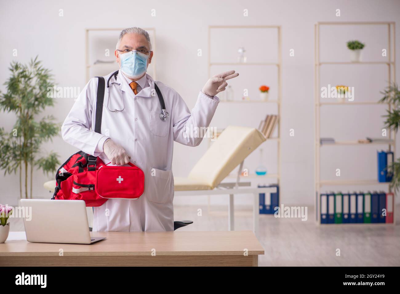 Old doctor in first aid concept Stock Photo - Alamy