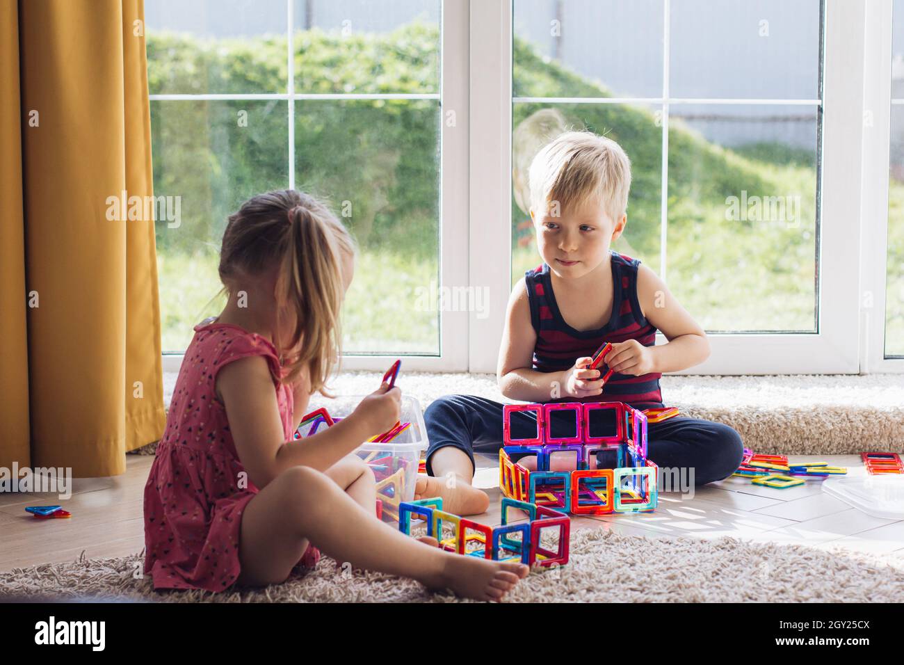 The child is playing with a multi-colored magnetic constructor ...