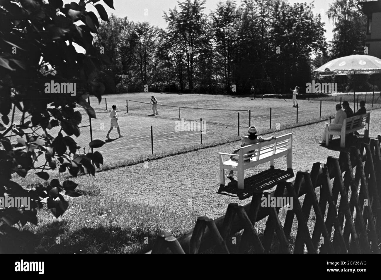 Tennisspieler bei einer Partie auf dem Spielfeld und ihr Publikum