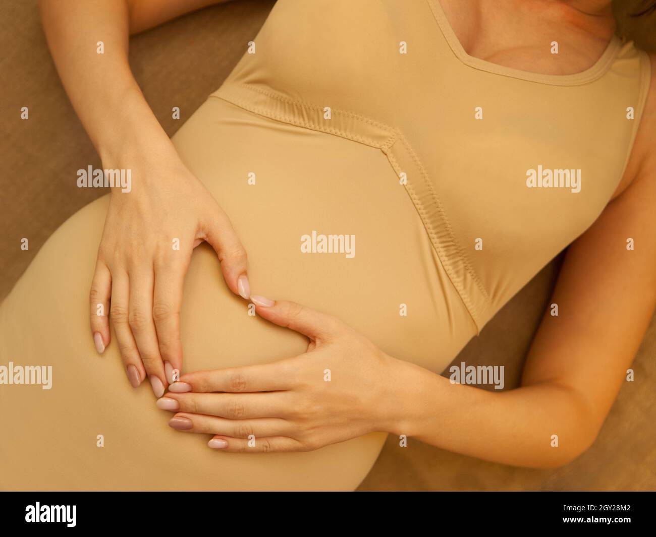 Hands showing a pregnancy belly cast decorated with lace and flower Stock  Photo - Alamy
