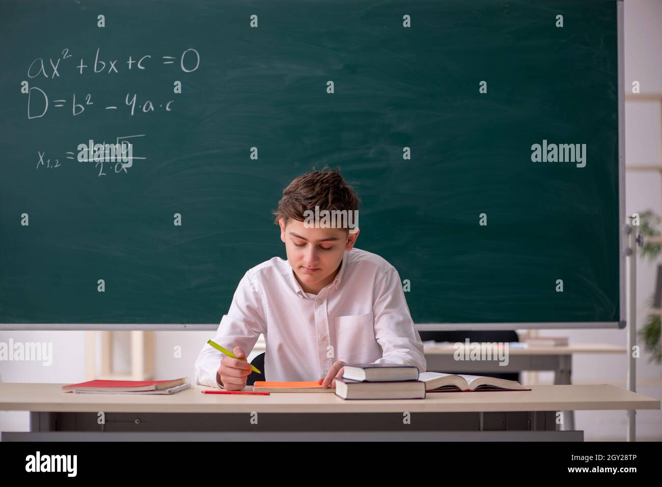 Schoolboy studying math in front of chalkboard Stock Photo - Alamy