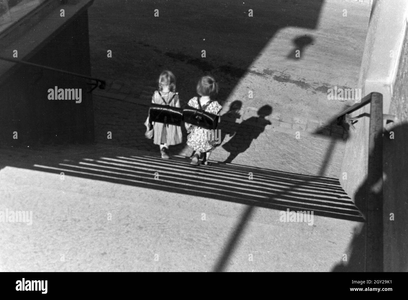 Zwei kleine Schulmädchen auf dem Heimweg, Deutsches Reich 1930er Jahre. Two little schoolgirls on their way home, Germany 1930s. Stock Photo