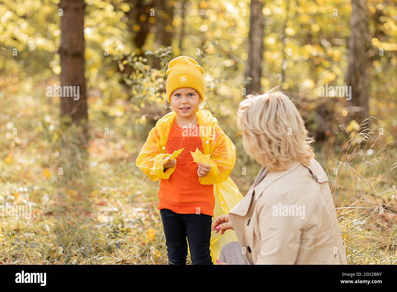 Photo of young woman mom is walking in autumn park with daughter little ...