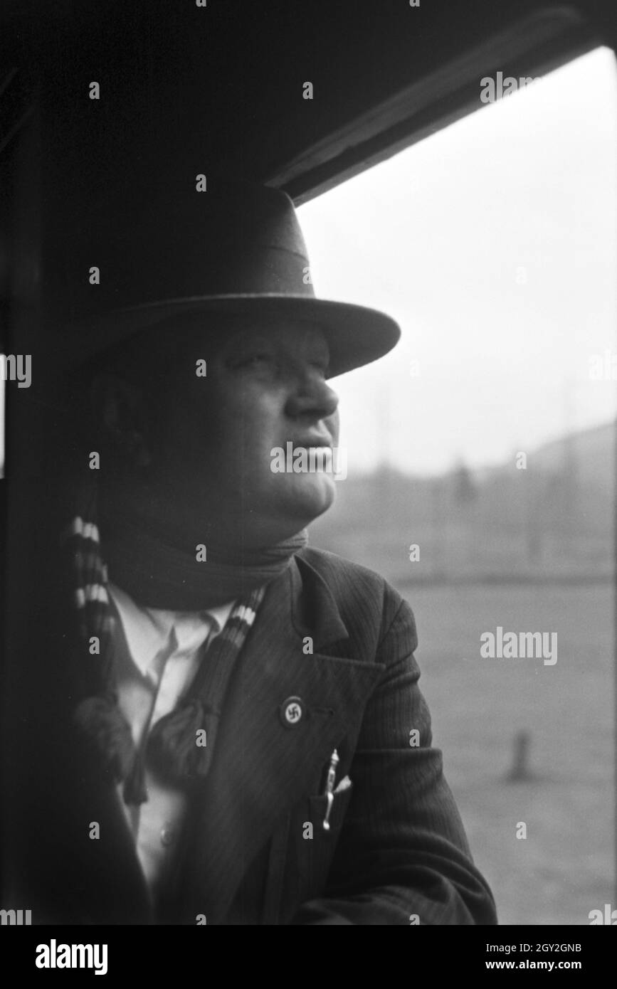 Ein Parteimitglied der NSDAP mit dem Hakenkreuzabzeichen auf der Reise durch Italien, 1930er Jahre. A Nazi Party member with a swastika badge on a train journey through Italy, 1930s. Stock Photo