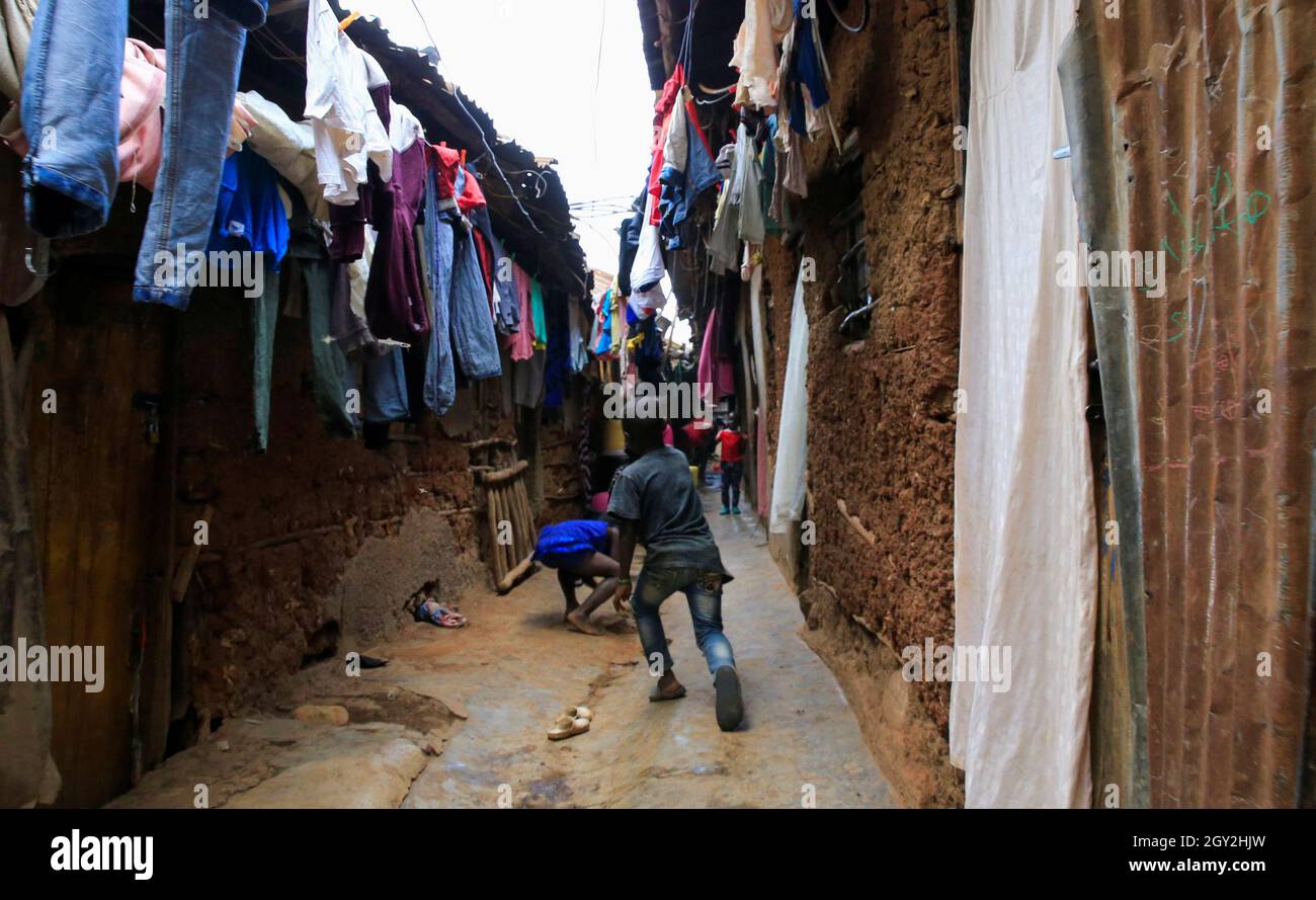 Children play in a courtyard under a hung out laundry amid the coronavirus disease (COVID-19) outbreak, within Kibera slums in Nairobi, Kenya October 6, 2021. REUTERS/Thomas Mukoya Stock Photo