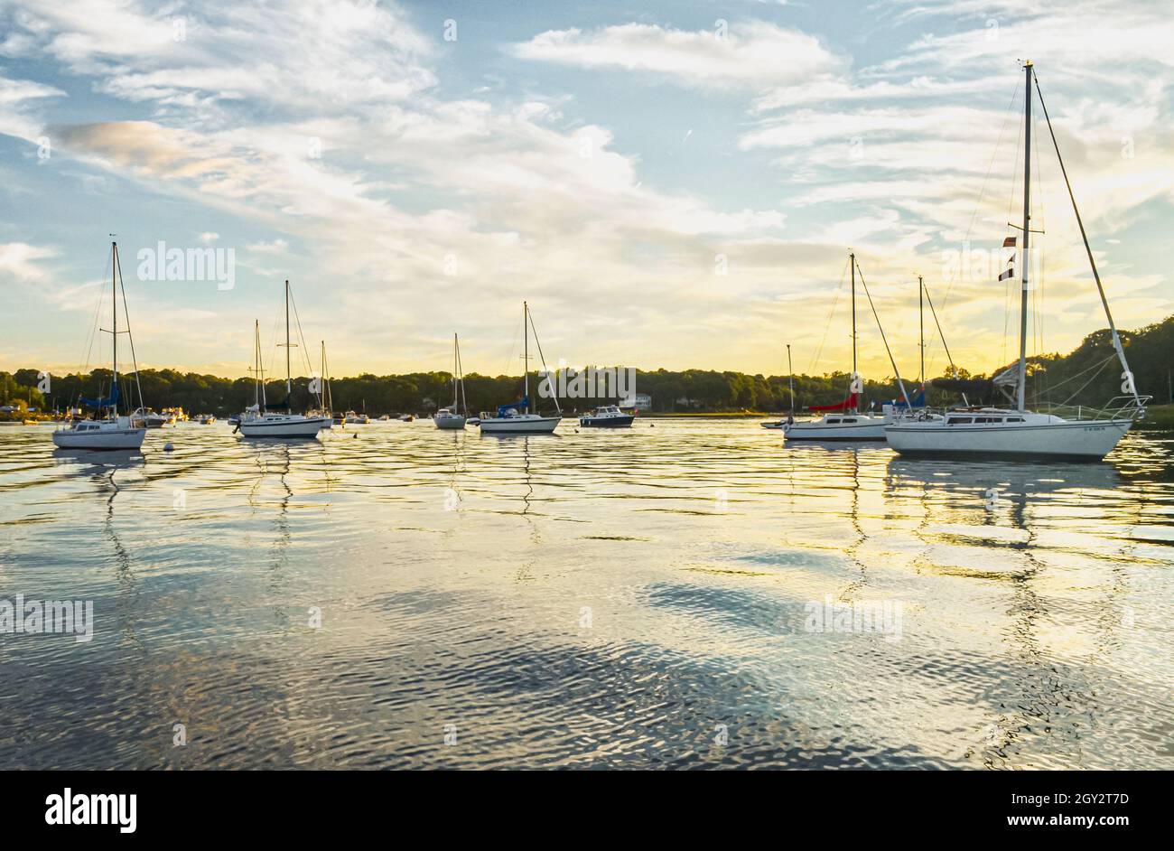 Sailboats moored in a placid harbor at sundown. Long Island, New York. Copy space. Stock Photo