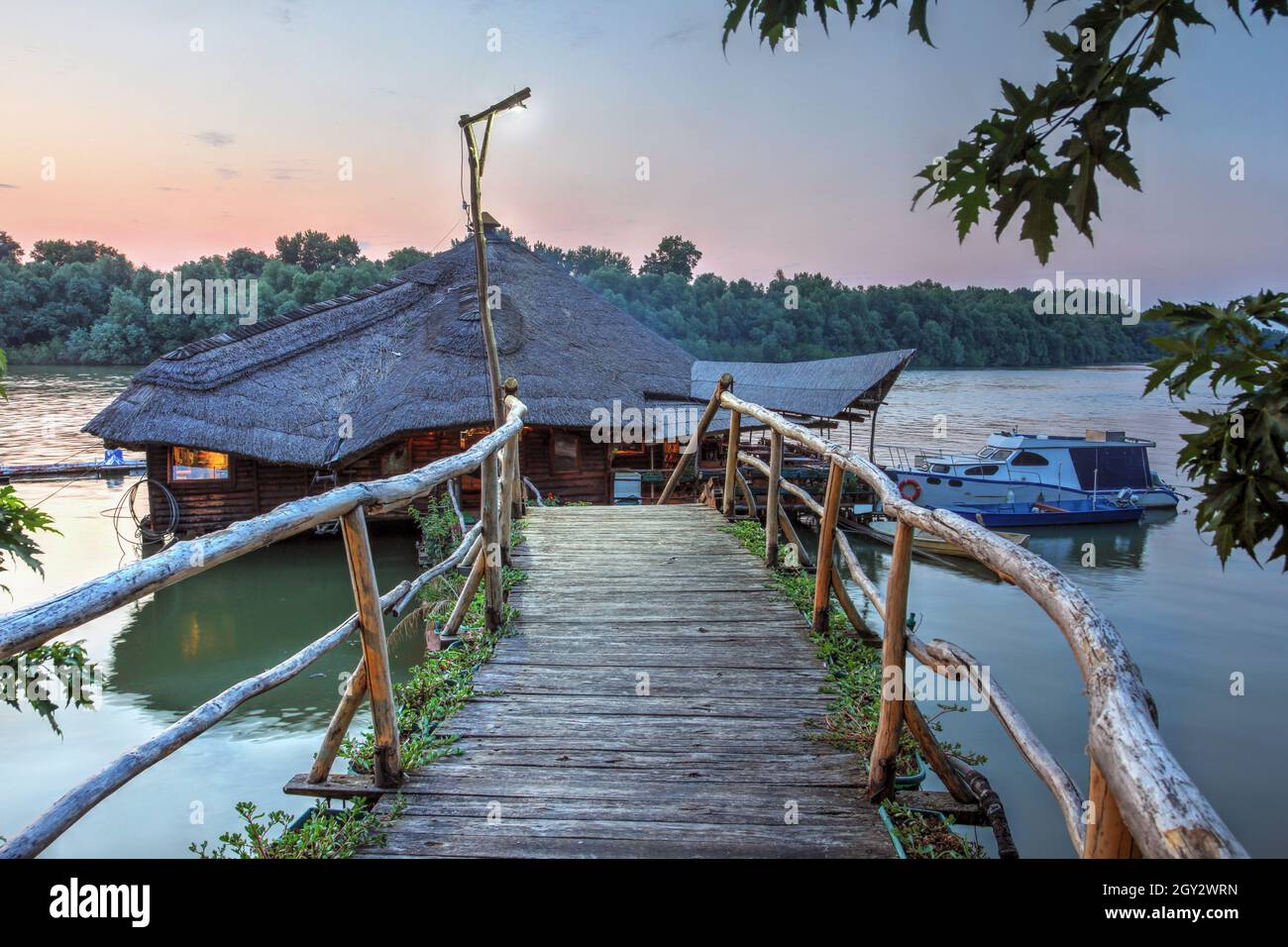 Beautiful summer sunset with the traditional rustic restaurant on silts Stara Koliba, on the Danube river in Belgrade, Serbia. Stock Photo